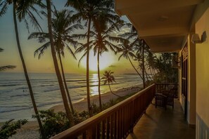 A balcony with a view of the ocean and palm trees at sunset. - Top Secret Beach hotel (Matara)
