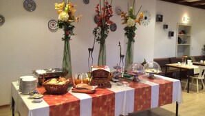 Una mesa de buffet con diferentes tipos de comida y jarrones decorativos.