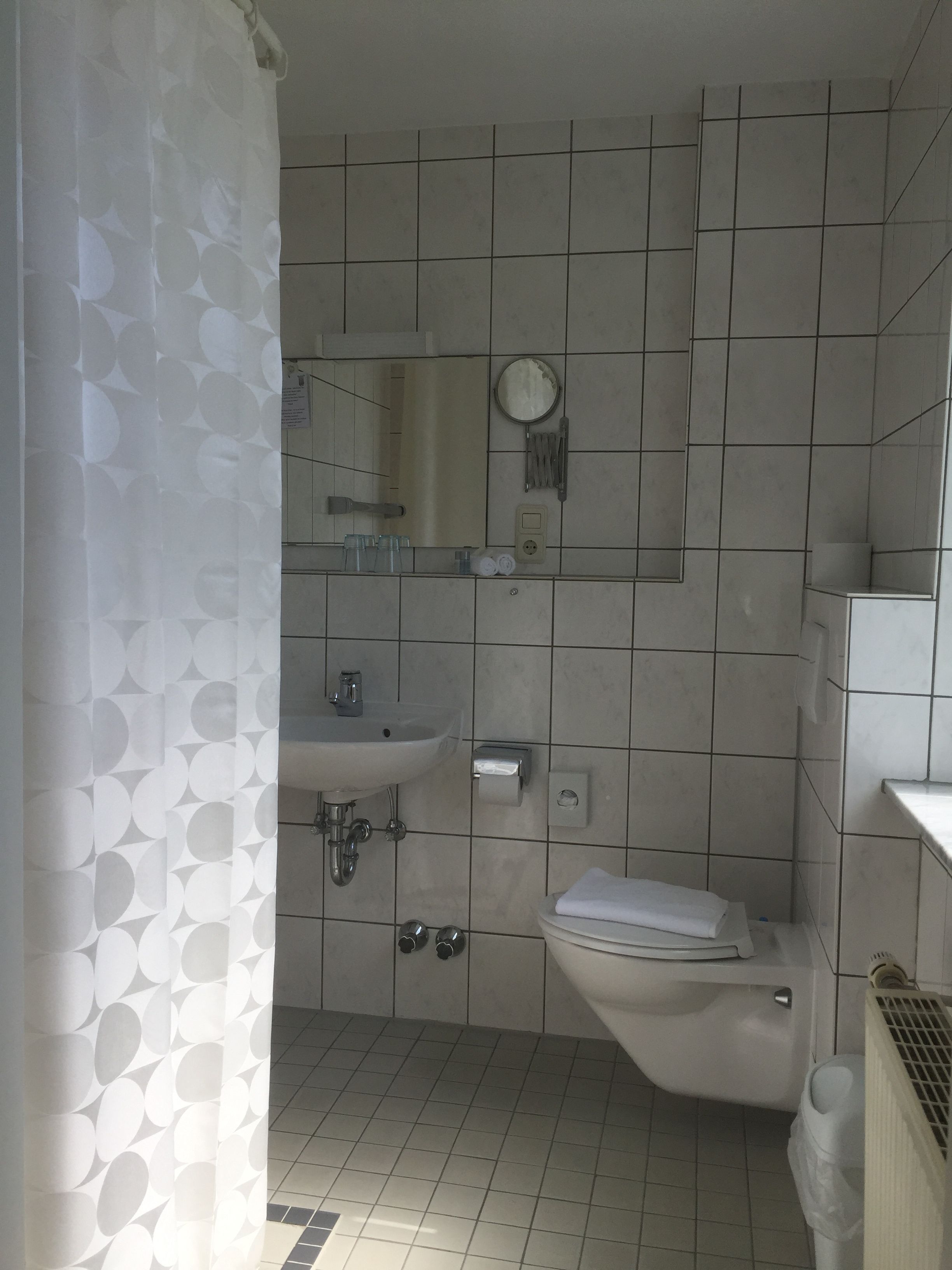 Une salle de bain avec des toilettes, un lavabo et un miroir.
