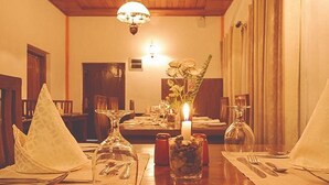 A dining table set with a candle, glassware, and a vase with flowers. - Avian Breeze (Nuwara Eliya)