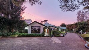 A residential house with a driveway leading to the entrance, surrounded by greenery and trees. - Avian Breeze (Nuwara Eliya)