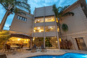 Una piscina al aire libre, sillones reclinables de piscina