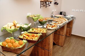 Una mesa de buffet con diferentes alimentos y un pequeño estante con adornos.