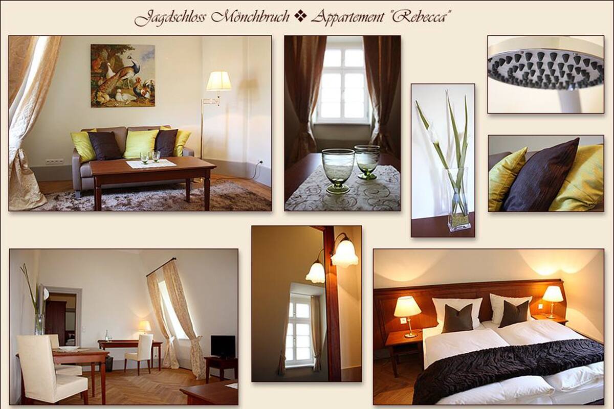 Hotelkamer met een bank, een eettafel, een bed met zwart dekbed en een schilderij aan de muur.