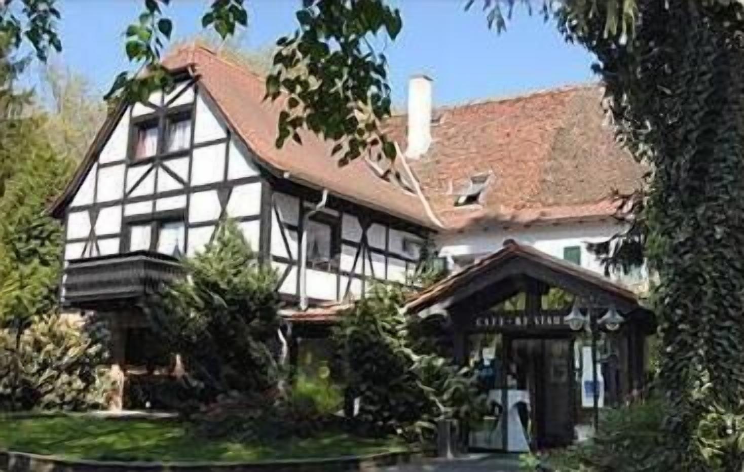 A traditional half-timbered house with a visible entrance and a small garden area.