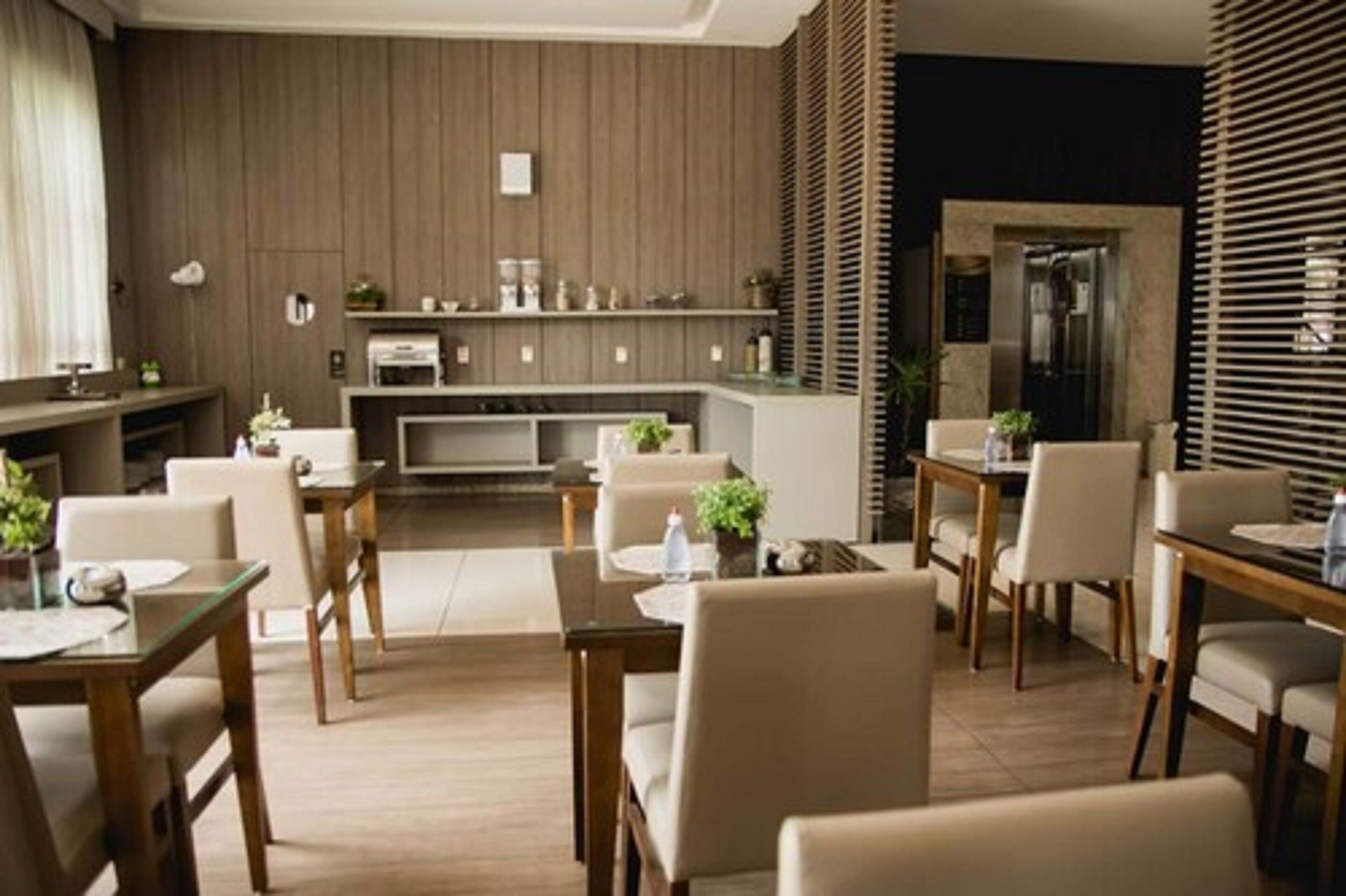A modern kitchen with wooden paneling, a central island, and a dining area with chairs and tables.