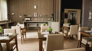 A modern kitchen with wooden paneling, a central island, and a dining area with chairs and tables.