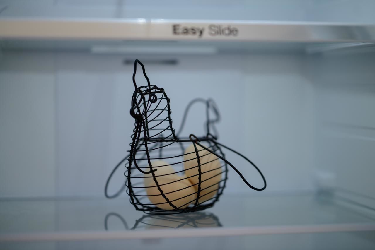 A wire basket with a handle on a reflective surface.