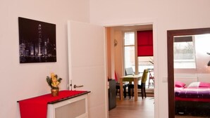 Ein Schlafzimmer mit Bett, Schreibtisch und Stuhl. Ein Fenster bietet einen Ausblick nach draußen.