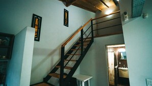 A staircase with wooden steps and black railings leading to an upper floor. - Brisas de Villa Gesell (Villa Gesell)