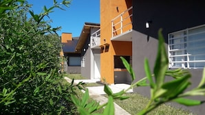 A modern building with a flat roof, a balcony, and a window. - Brisas de Villa Gesell (Villa Gesell)