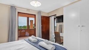 A hotel room with a bed, a balcony, and a television. - San Lameer Villa Rentals 2826 (Southbroom)