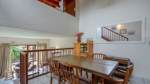 A dining area with a wooden table and chairs, a cabinet with bottles, and a view of the outside. - San Lameer Villa Rentals 3311 (Southbroom)