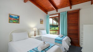 A hotel room with two beds, a wooden ceiling, a window with curtains, and a painting on the wall. - San Lameer Villa Rentals 3311 (Southbroom)