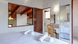 A hotel room with a large bed, a wooden ceiling, a chair, and a mirror. - San Lameer Villa Rentals 3311 (Southbroom)
