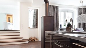 A modern kitchen with a central island, a built-in stove, and a dining area with a chandelier. - Konventchen (Aschaffenburg)