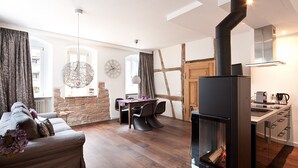 A modern living room with a fireplace, dining area, and kitchen. - Konventchen (Aschaffenburg)