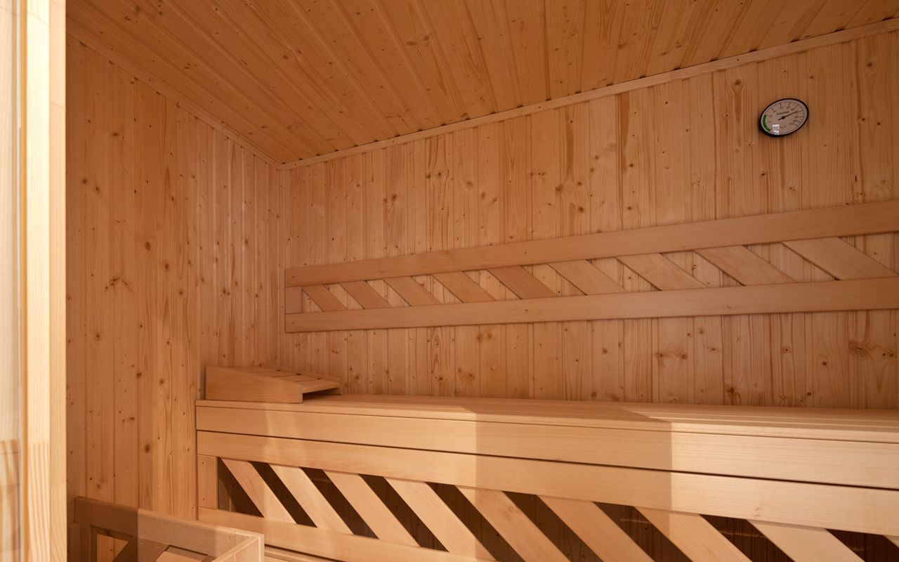 Puisesta laudelavasta ja seinällä olevasta kellosta varustettu sauna.