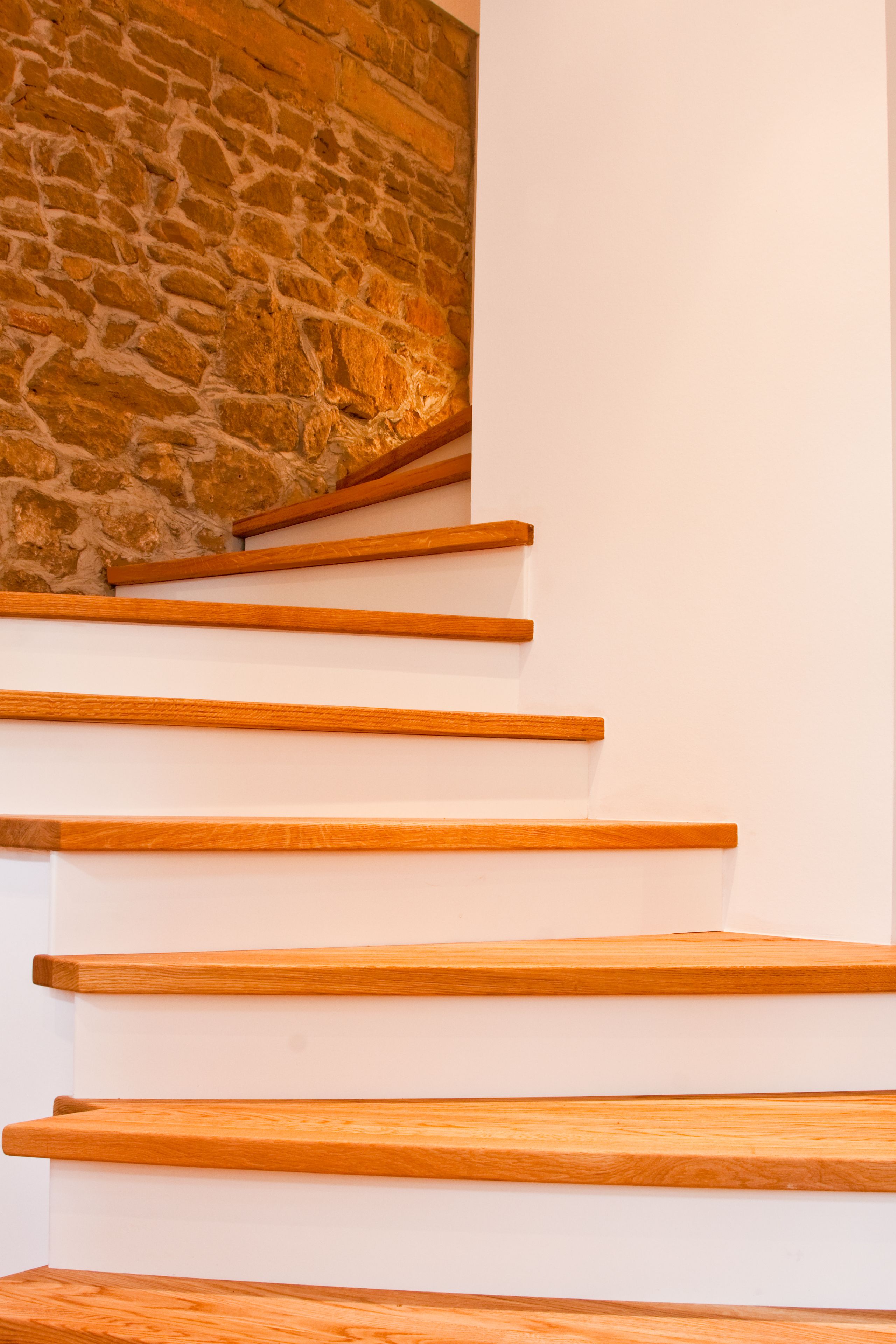 Eine Treppe mit Holzboden und einer Steinwand.