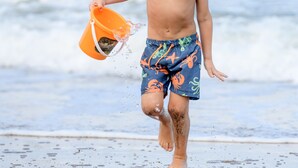 A child running on a beach holding a bucket. - San Lameer Villa Rentals 3501 (Southbroom)