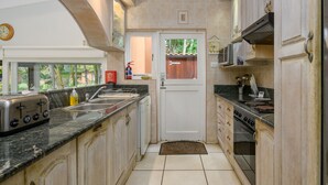 A kitchen with a toaster, sink, stove, and cabinets. - San Lameer Villa Rentals  2301 (Southbroom)