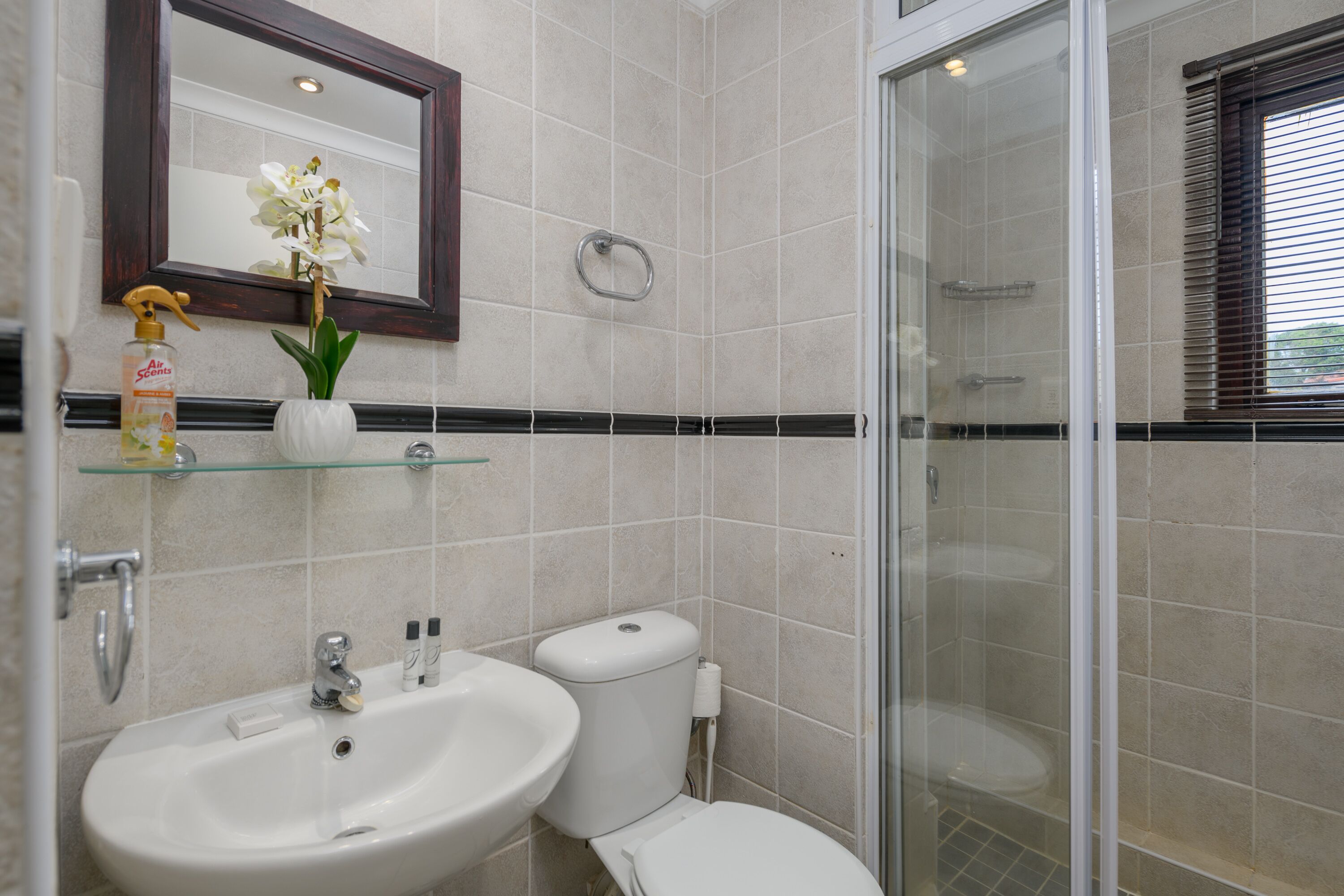 A bathroom with a sink, toilet, and glass-enclosed shower.