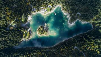 Vista aérea de una isla aislada con un lago turquesa cristalino, rodeada de un denso bosque.