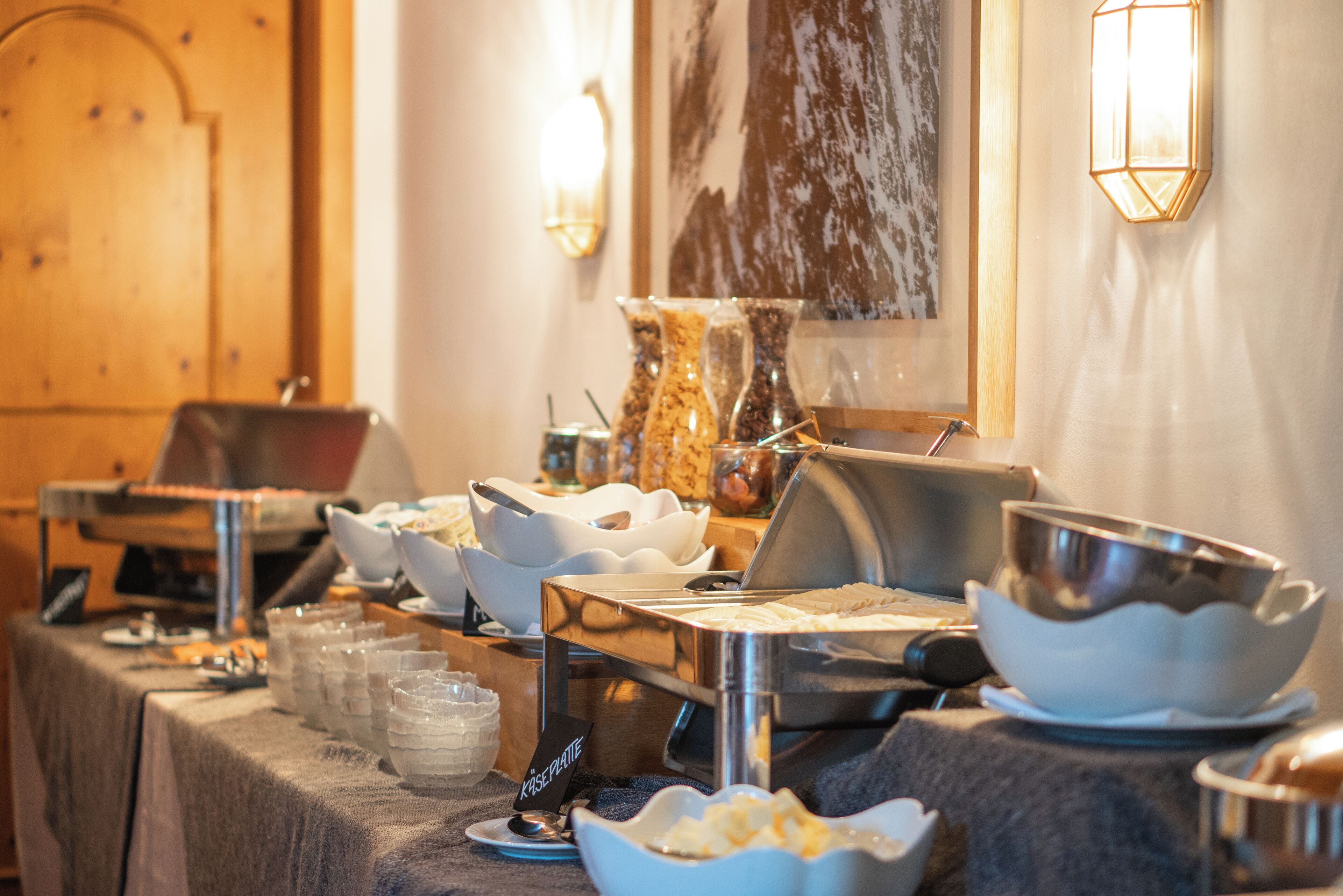 Un buffet avec différents récipients contenant de la nourriture et des ustensiles de service.