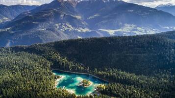 Un paisaje montañoso con un lago turquesa rodeado de densos bosques.