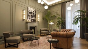 A modern living room with a fireplace, leather sofa, armchairs, and a coffee table. - Maldà Singular Hotel (Barcelona)