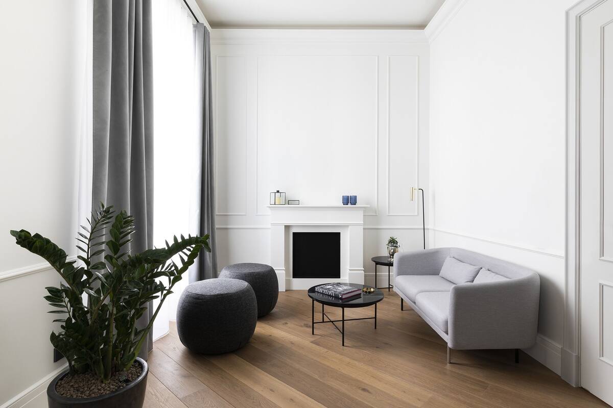 A modern living room with a grey sofa, a coffee table, and a potted plant.