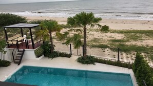 A pool area with a view of the beach and ocean. - La Playa Beach Front Pool Villa Cha-am (Cha-am)