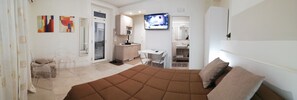 Un dormitorio moderno con una cama grande, un escritorio y un televisor.