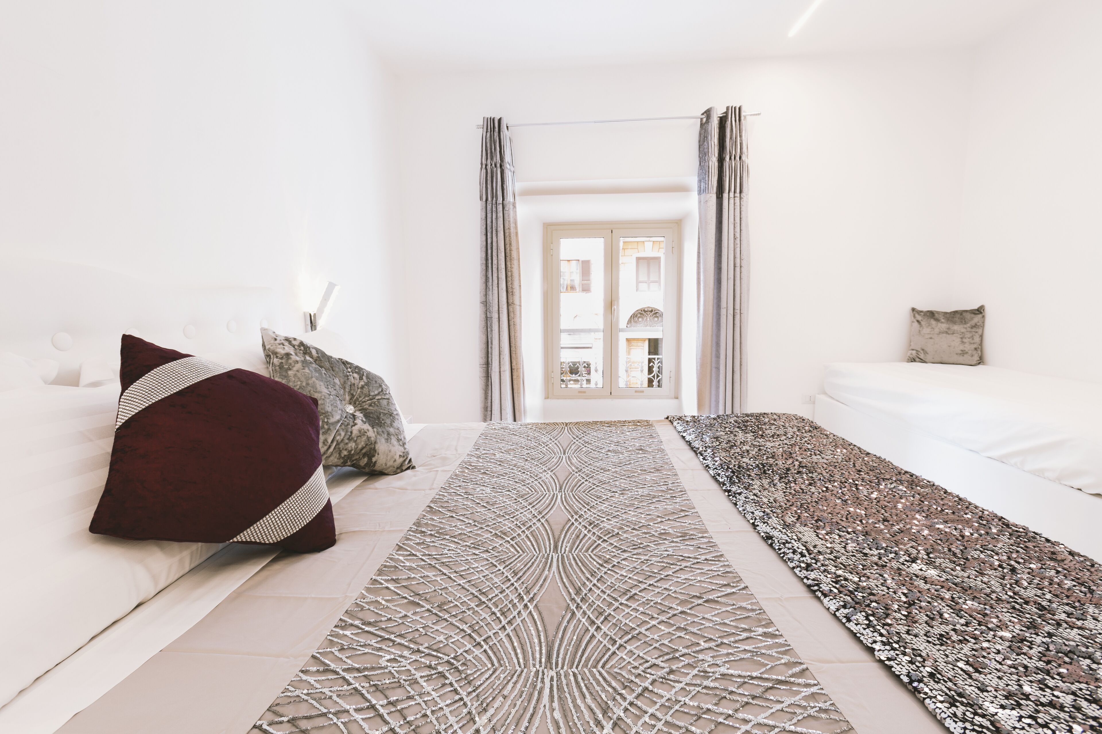 Une chambre d’hôtel moderne avec un grand lit, un tapis décoratif et une vue sur la ville par la fenêtre.