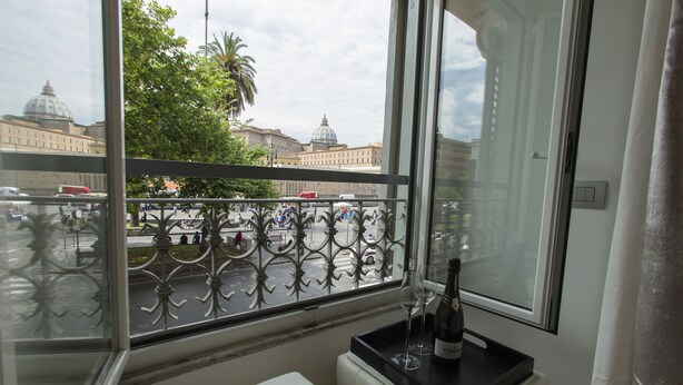 A balcony with a view of a cityscape, including buildings and a street. - San Pietro Grand Suite (Rome)