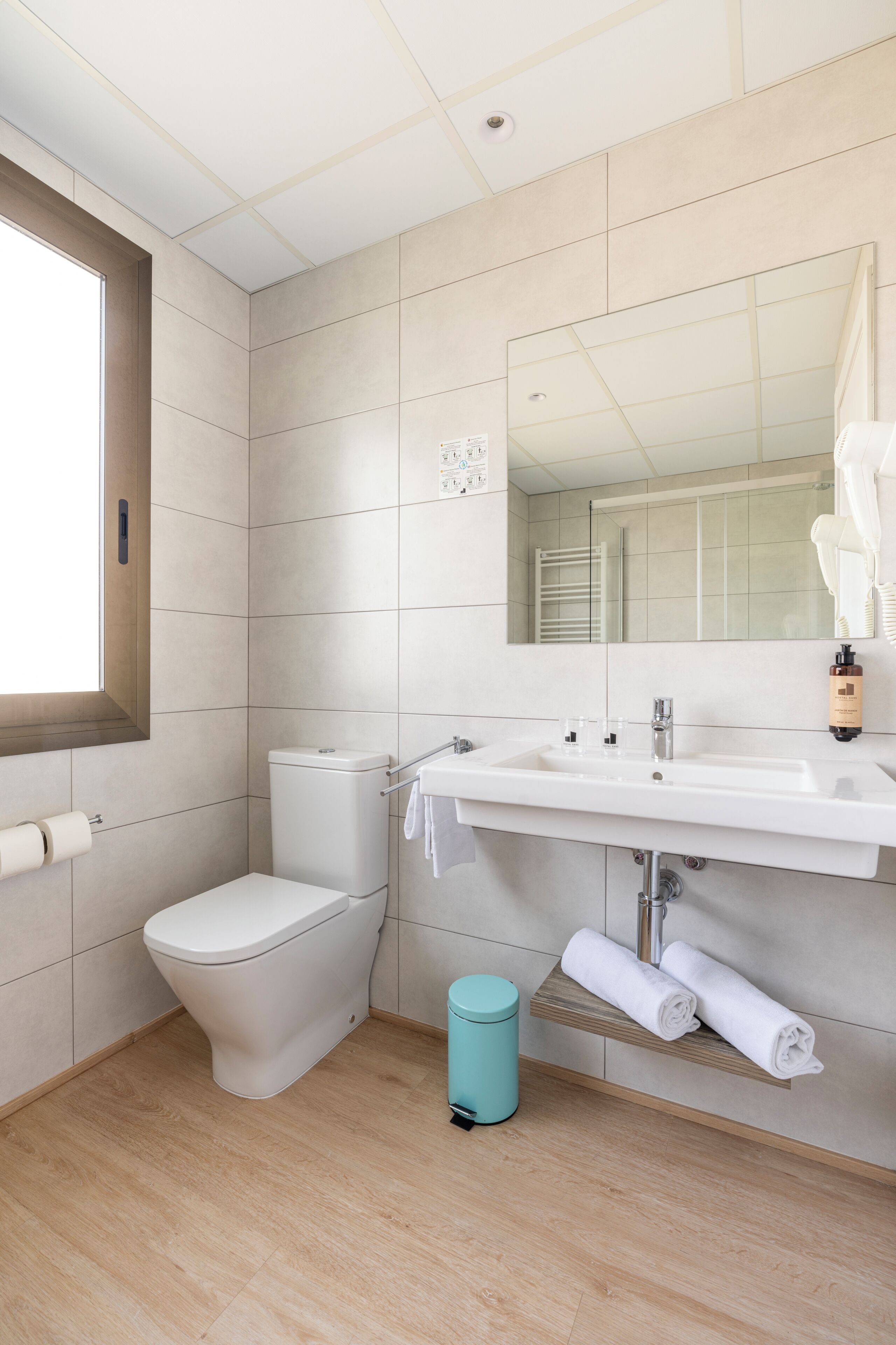 A modern bathroom with a toilet, sink, and mirror.