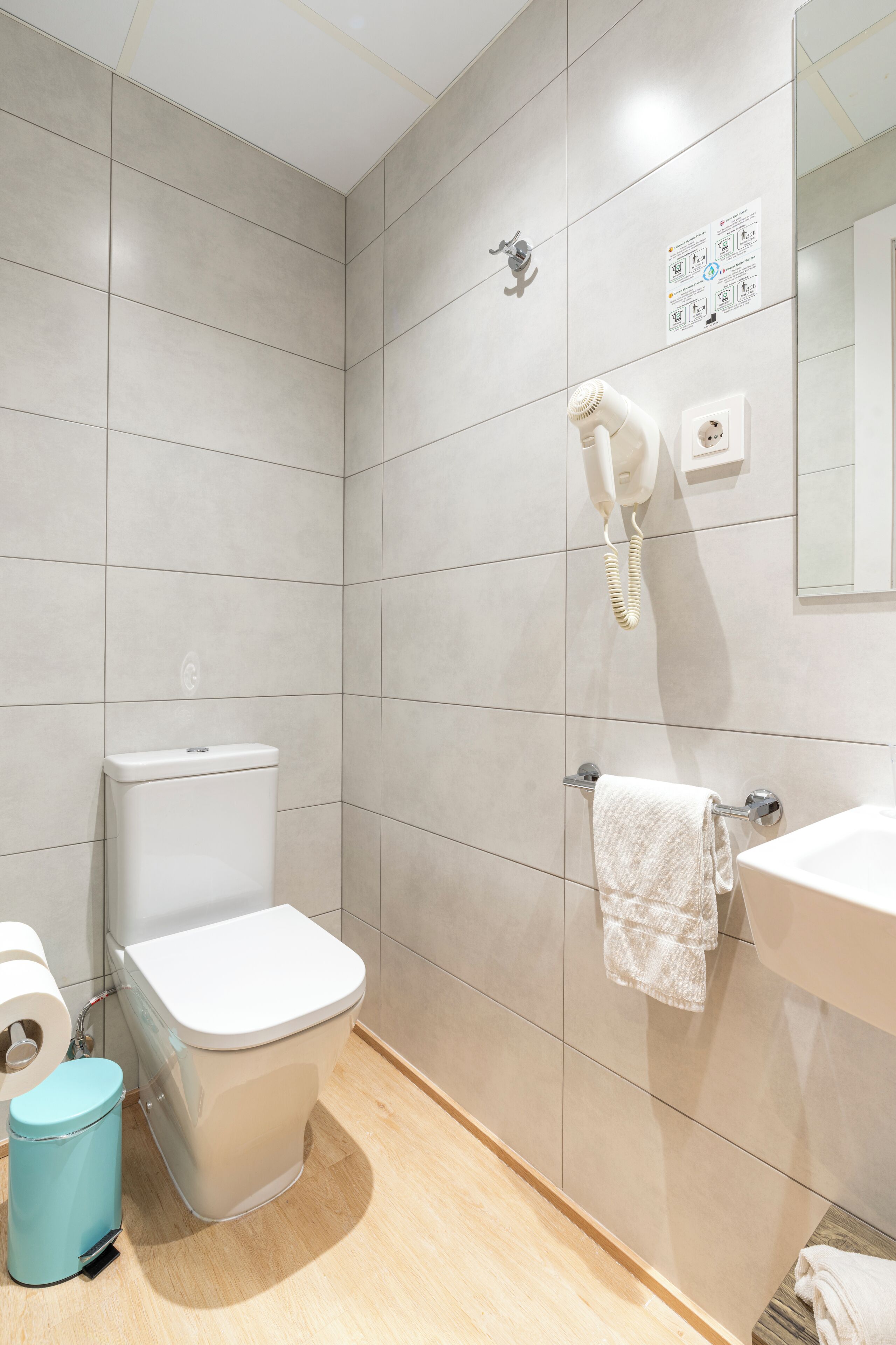 Un baño moderno con inodoro, lavamanos y secador de pelo.