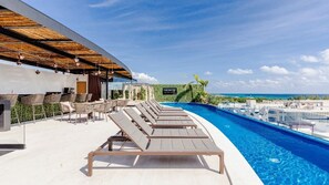 Zona de piscina en la azotea con sillones de descanso y un cartel que dice "The Shore".