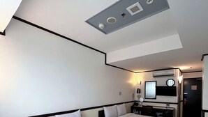 A hotel room with two beds, a desk, a chair, a television, and a ceiling light fixture. - Toyoko Inn Cebu (Mandaue)