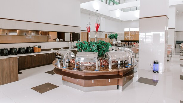 A modern hotel lobby with a central buffet area, a high ceiling, and a view of the upper floor. - Toyoko Inn Cebu (Mandaue)