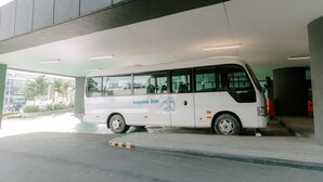 A white bus with "toyoko inn" branding parked under a building. - Toyoko Inn Cebu (Mandaue)