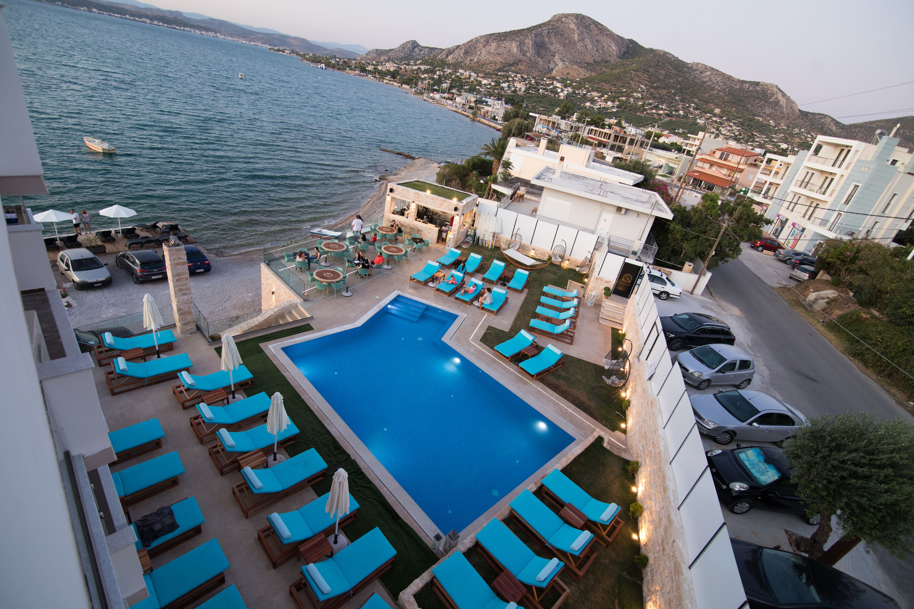 Un resort con piscina, sillas de descanso y vista al mar.