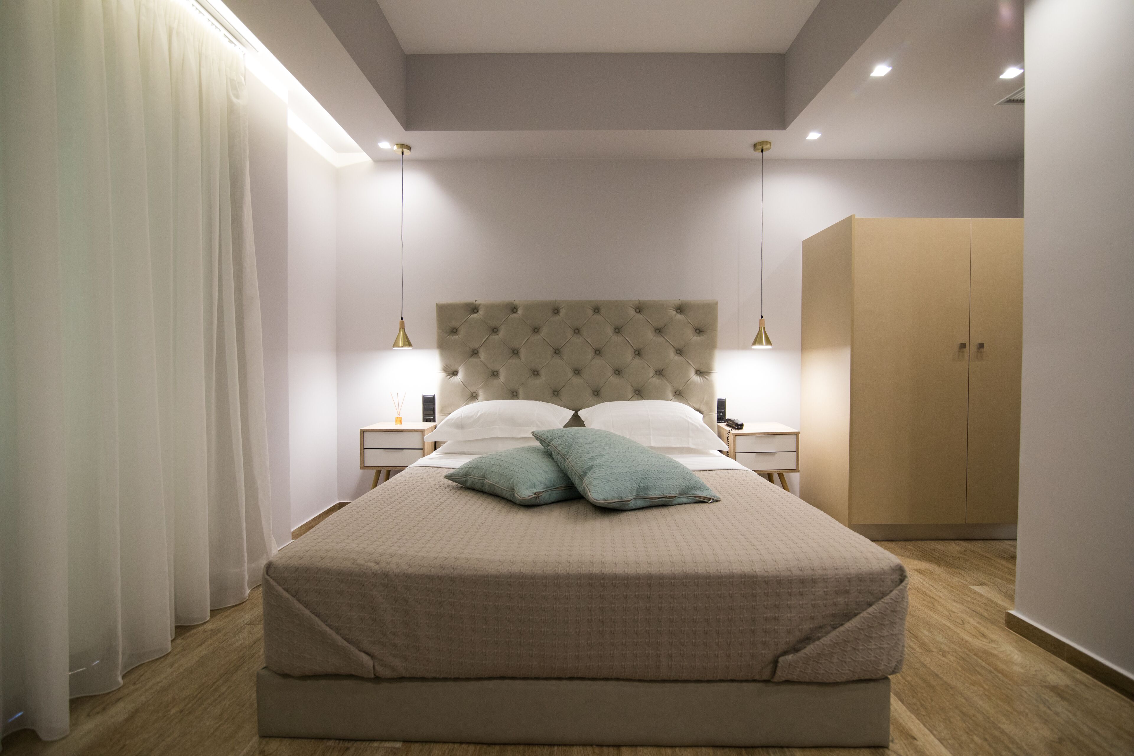Ein ordentlich eingerichtetes Schlafzimmer mit einem großen Bett, zwei Nachttischen und einem Kleiderschrank.