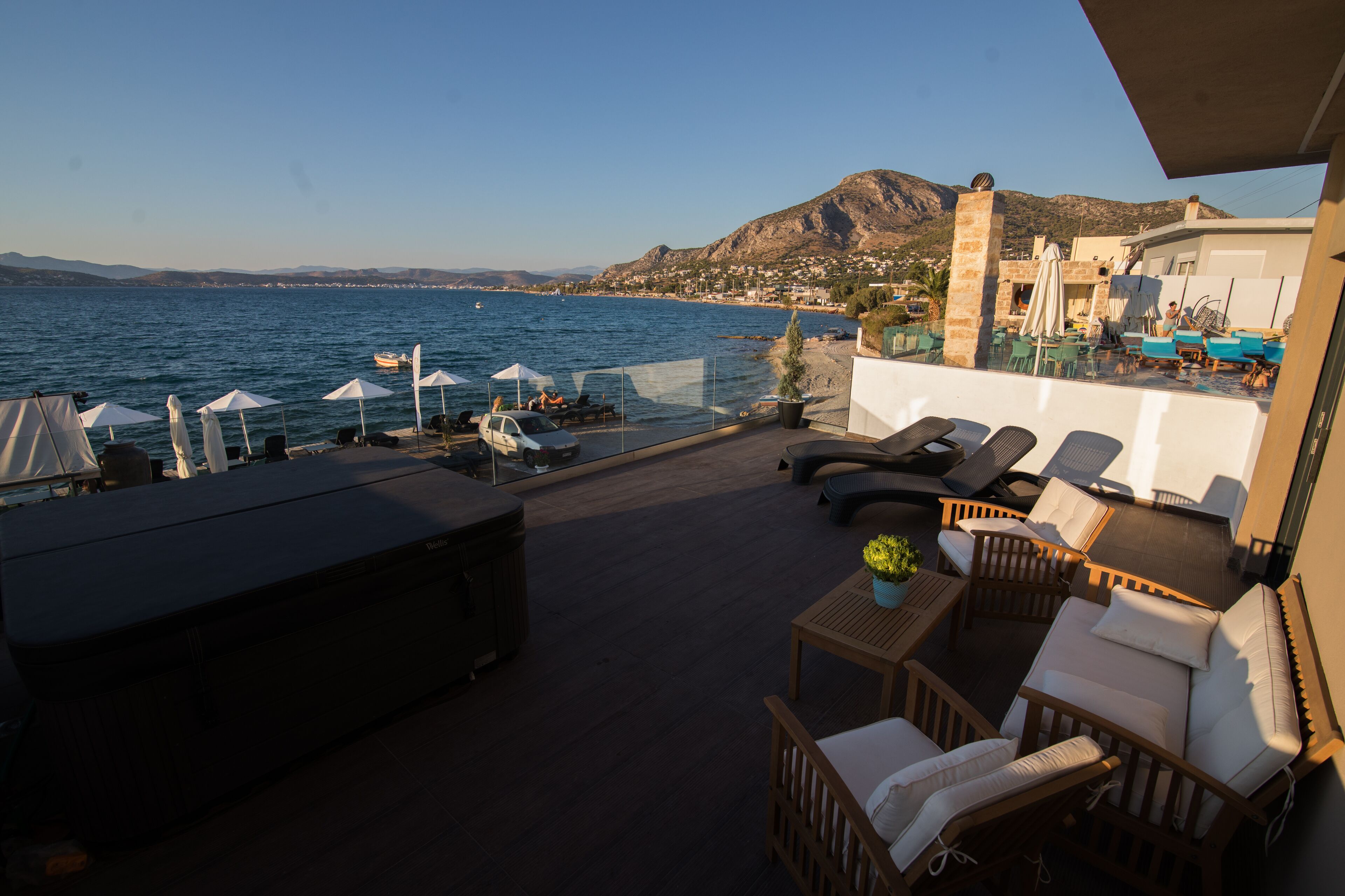 Una terraza con mobiliario exterior, piscina y vistas al mar y a las montañas.