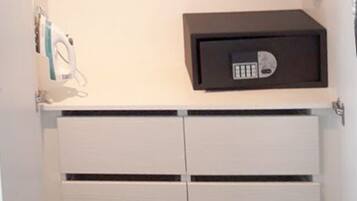 A white cabinet with two drawers and a black object on top.