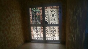 Una habitación con piso de baldosas y una puerta con adornos de metal.