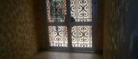 A room with a tiled floor and a door with decorative metal bars.