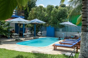 Relax by the serene pool surrounded by lush greenery and comfortable lounge chairs.