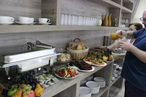 Una mesa de buffet con diversos alimentos y bebidas.