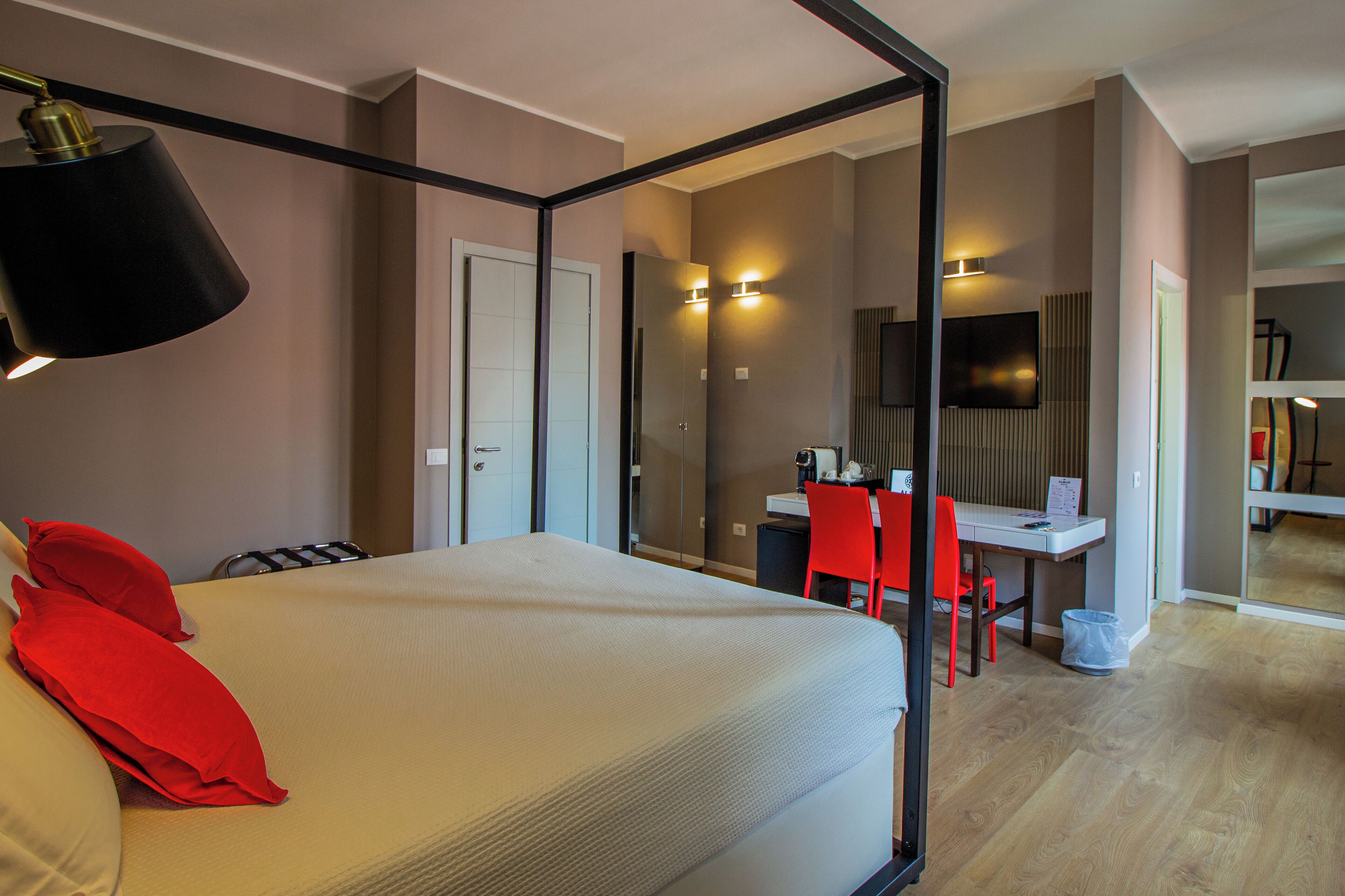 A hotel room with a bed, a desk, a chair, and a television.